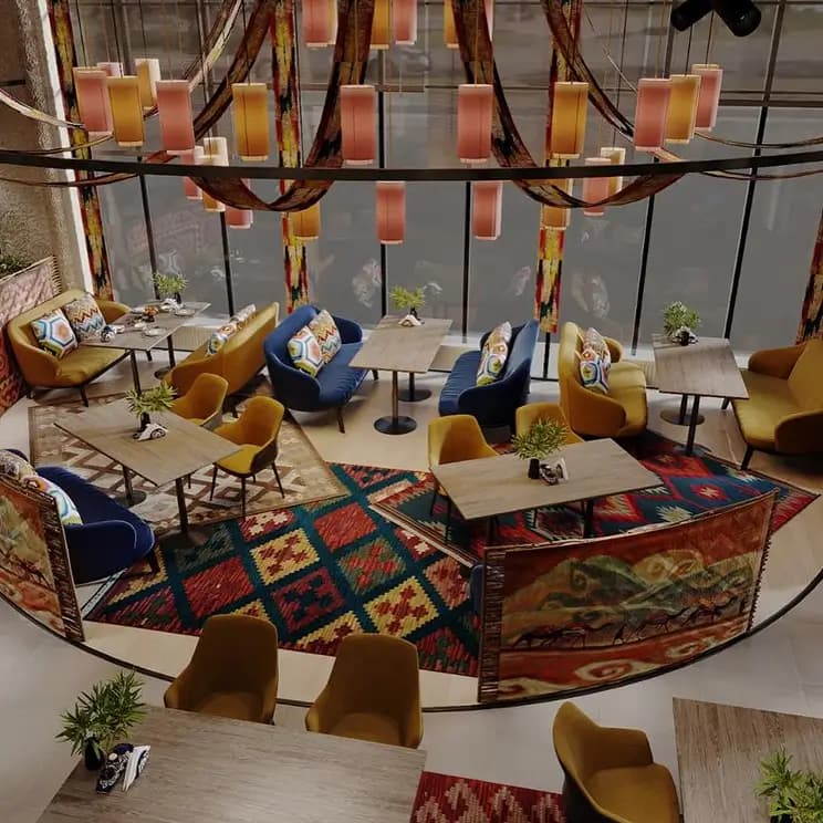 Стильное кафе с панорамными окнами, яркими диванами и коврами с национальными узорами.