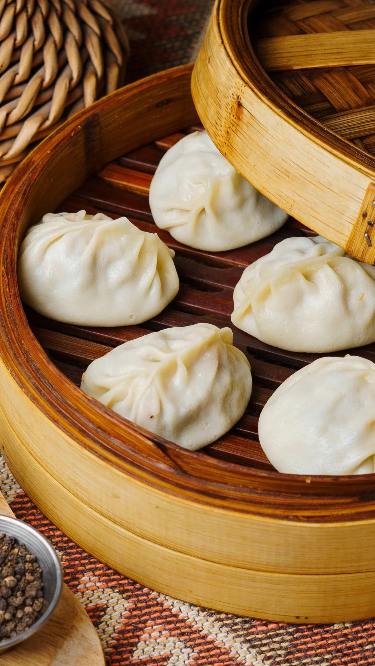 Традиционные манты на пару в бамбуковой корзине для подачи.